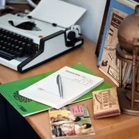 Gesprächs-Notizblock mit Füllfederhalter neben alter Schreibmaschine